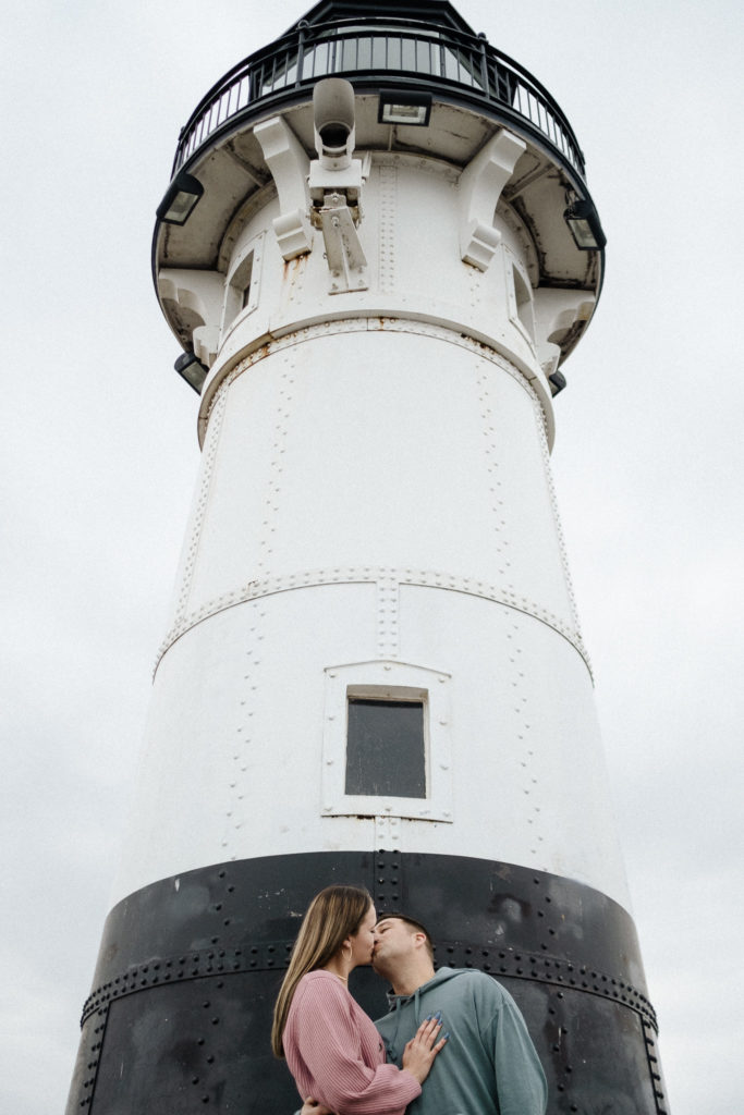 Couple kissing under the lighthouse in Canal Park, Duluth MN