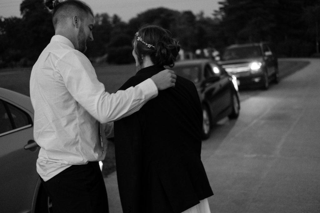 Groom offering his bride the suit jacket off his back as they walk back to the cars. Cleveland Ohio.