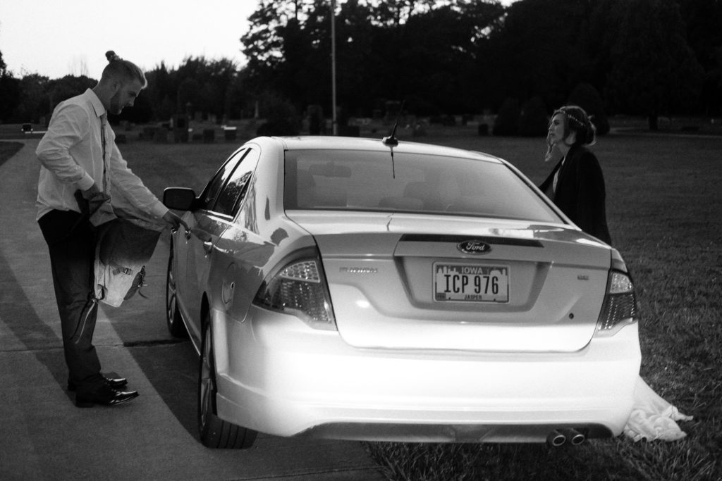 Bride and groom climbing into the getaway car at dusk as they leave Cleveland Ohio for their honeymoon. 
