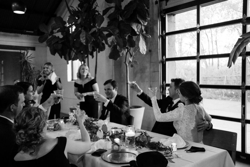 Newlywed couple toasting to their wedding party after their speeches. At Paikka MN, a St Paul wedding venue.