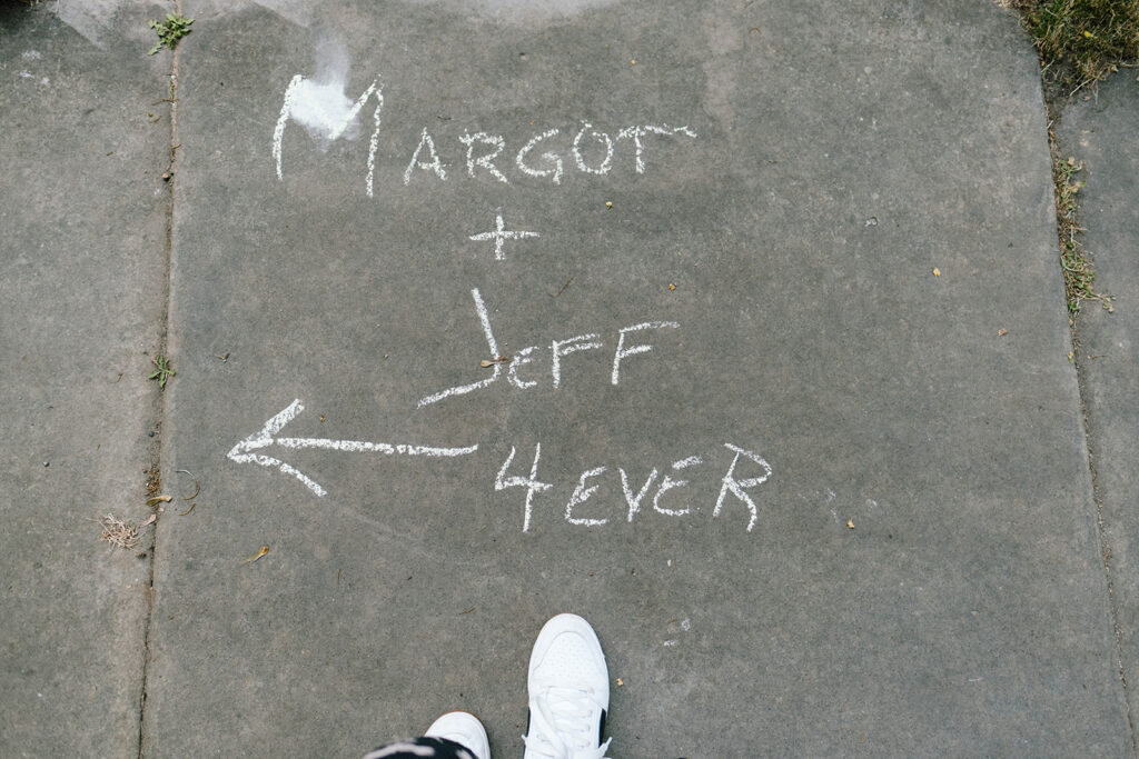 Chicago wedding photographer. Photo of sidewalk with the phrase "Margot + Jeff 4 Ever" written in chalk with an arrow pointing to the left. 