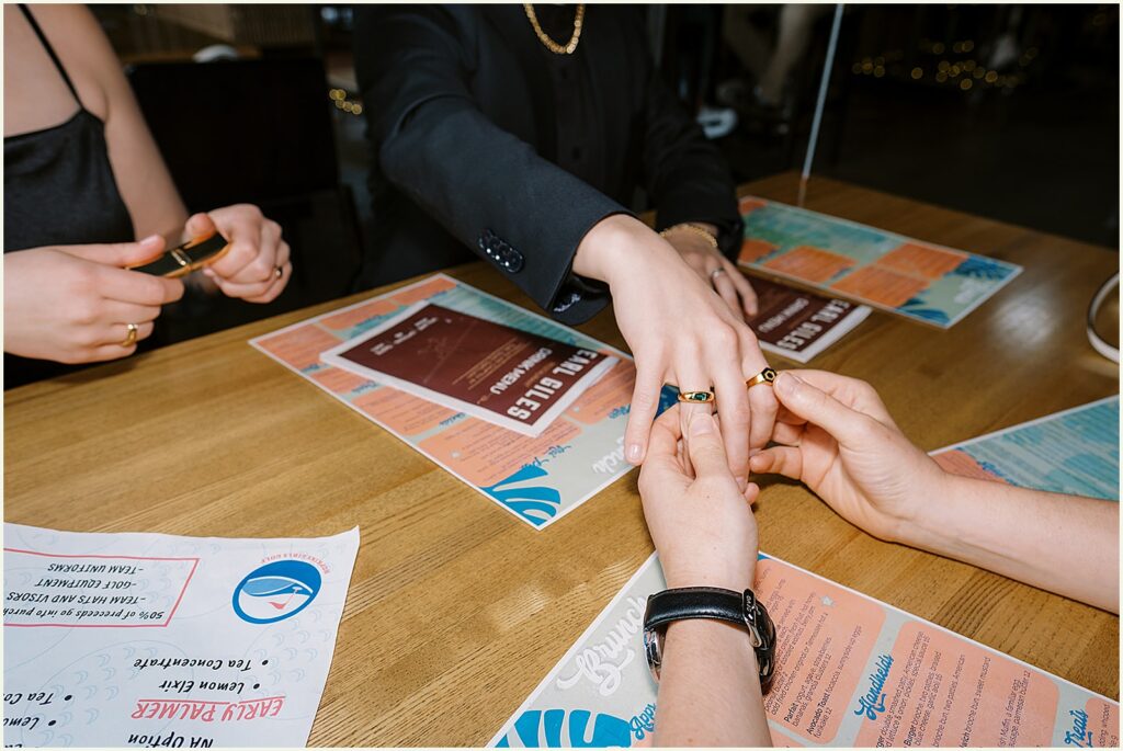 A marrier shows their wedding ring to a friend.