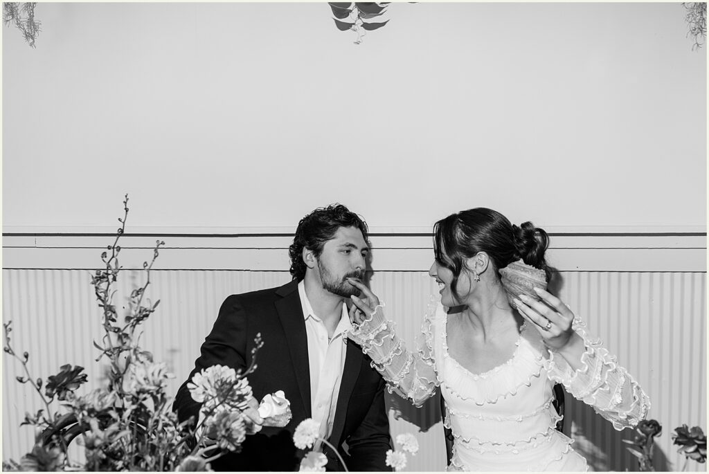 A bride and groom sit at a table eating pastries at Diane's Place.