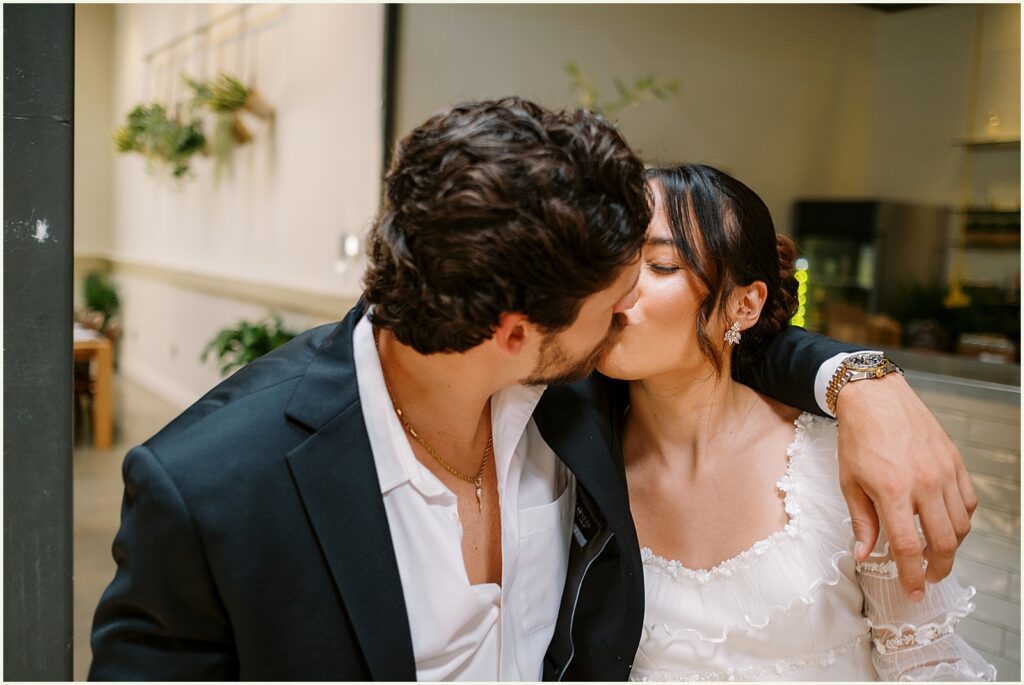 A groom kisses a bride.