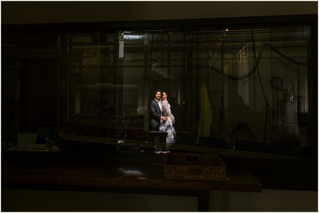 A bride and groom stand in a patch of sunlight inside Diane's Place.