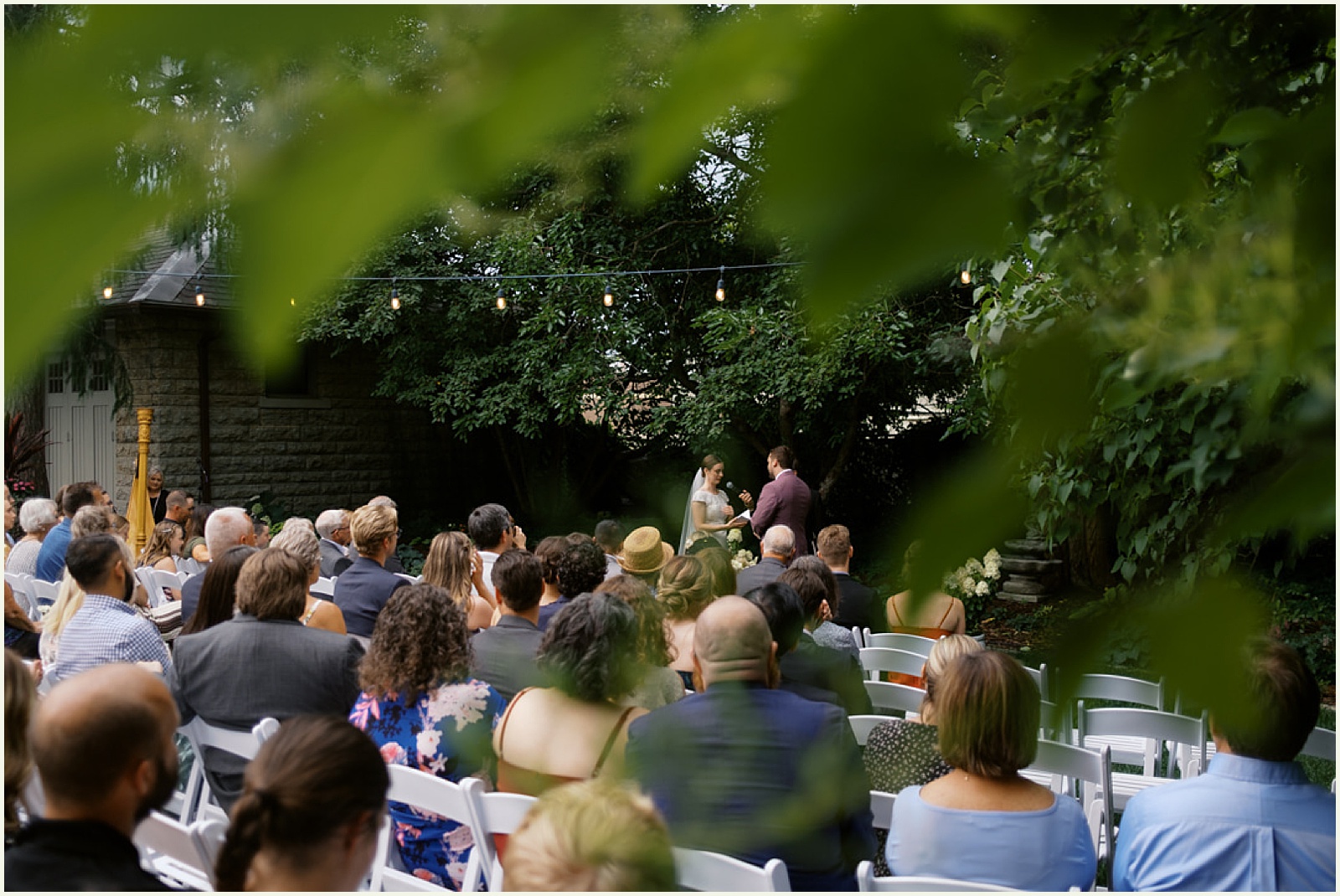 Wedding guests watch a ceremony outdoors at the St. Paul University Club.