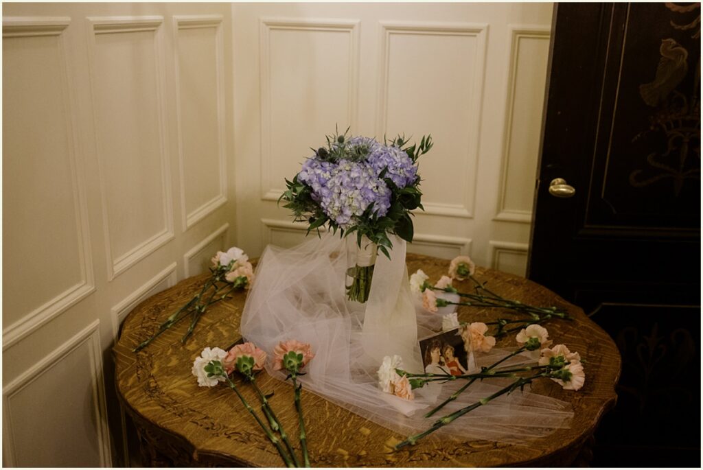 A bouquet of hydrangeas sits on a side table.